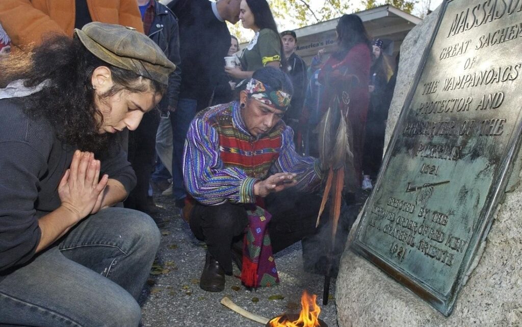 Supporters of Native Americans pause following a prayer during the 38th National Day of Mourning at Coles Hill in Plymouth, Mass., on Nov. 22, 2007. Denouncing centuries of racism and mistreatment of Indigenous people, members of Native American tribes from around New England will gather on Thanksgiving 2021 for a solemn National Day of Mourning observance. Lisa Poole/AP