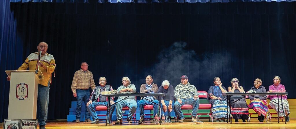 Manny Iron Hawk (far left at podium) is the spokesperson for the HAWK (Heartbeat at Wounded Knee) 1890 Descendants Group from Cheyenne River. Iron Hawk and other Wounded Knee descendants spoke at a special assembly for Cheyenne-Eagle Butte Middle School and High School students. (Photo courtesy of Marlis Afraid of Hawk)