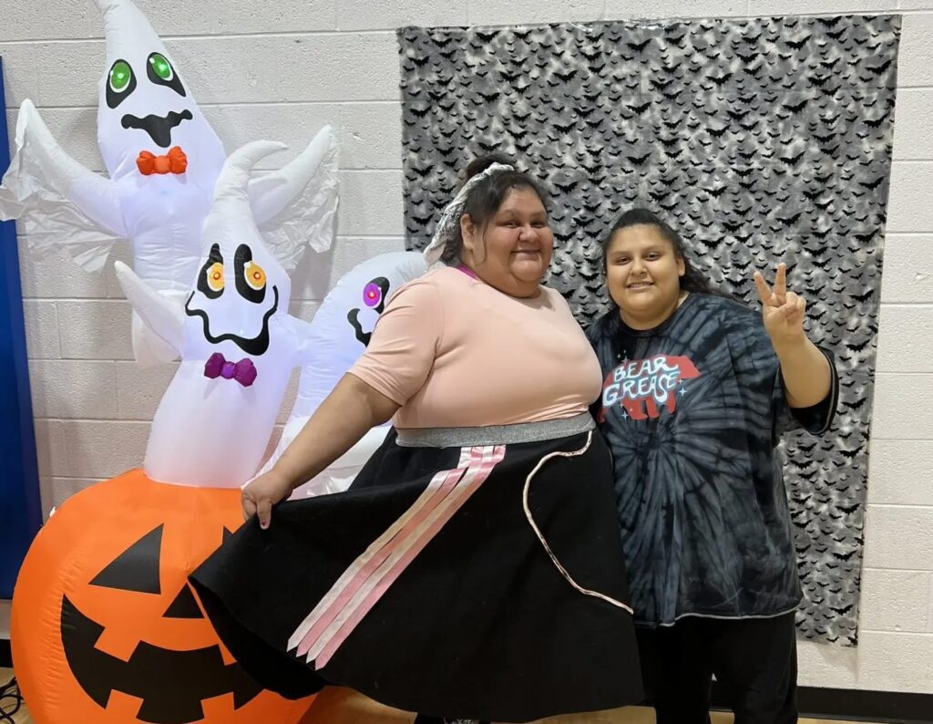 Valerie Siqueiros regularly attends IPAC meetings, council sessions and events with a smile. Here she and her 14-year-old daughter Christina are pictured participating in a Halloween costume contest at Sacred Pipe Resource Center in October 2024. (Photo by Cheryl Kary)