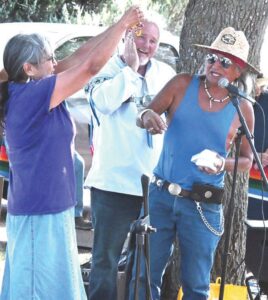 Phil Little Thunder gives a gift to his cousin Karen Little Thunder. The family gathered beneath the early autumn sun to commemorate the return of the Lakota items. (Jessica Wade, Nebraska Public Media)