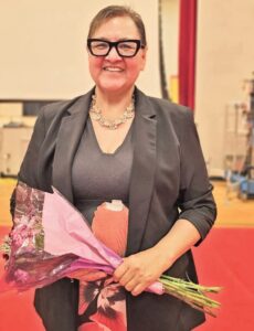 Superintendent Danielle Walking Eagle receives flowers during a May 15, 2026 celebration at Saint Francis Indian School, marking the school’s rise from “Needs Improvement” to “Approaching Expectations” under the BIE accountability system.