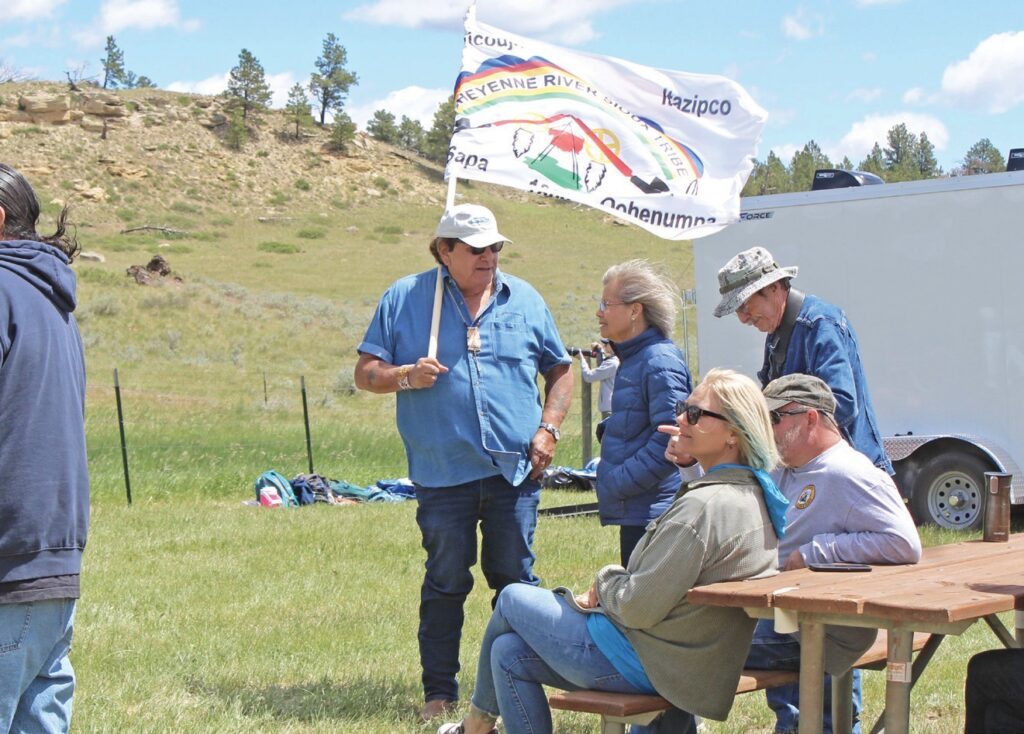 Donovan Sprague carries the Cheyenne River Sioux Tribe flag after noticing the tribe was missing from the event agenda, ensuring the Mnicoujou and Itazipco warriors who fought at the Rosebud were not forgotten during Remembering the Rosebud: 150 Years of Courage and Legacy. (Photo by Ernestine Anunkasan Hopa)